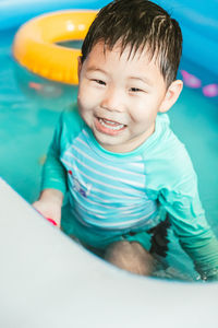 High angle view of cute baby boy sitting in swimming pool