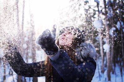 Woman having fun with snow during winter