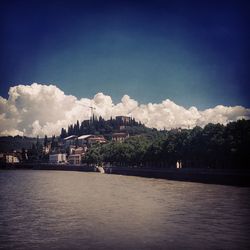 Scenic view of calm river against cloudy sky