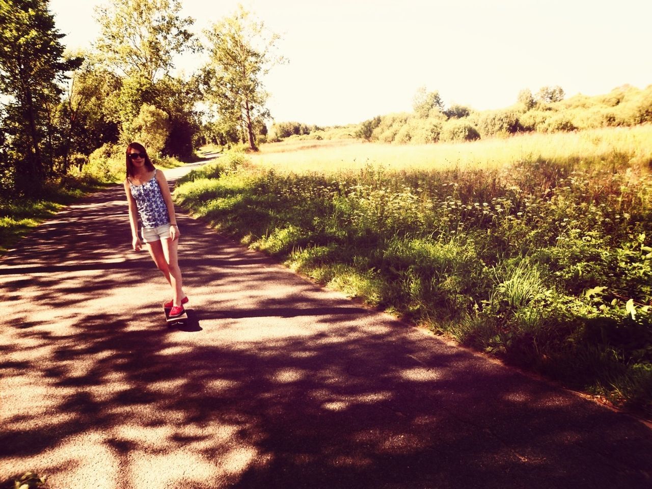 full length, lifestyles, casual clothing, leisure activity, walking, rear view, the way forward, clear sky, sunlight, grass, standing, men, dirt road, tree, shadow, person, footpath, road