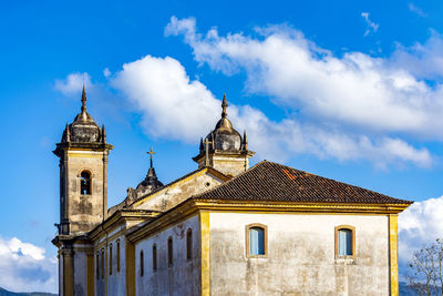 Towers of  baroque church seen from behind in the city of ouro preto during dusk with the mountains