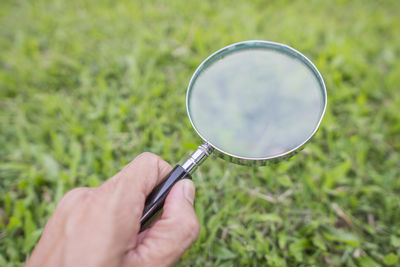 Midsection of person holding umbrella against plants