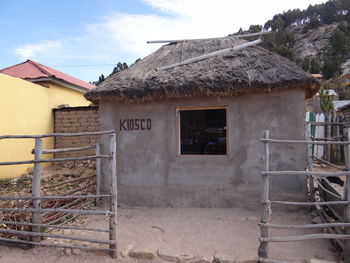 Exterior of houses by village against sky