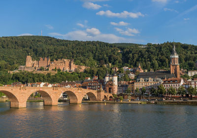 Arch bridge over river against buildings