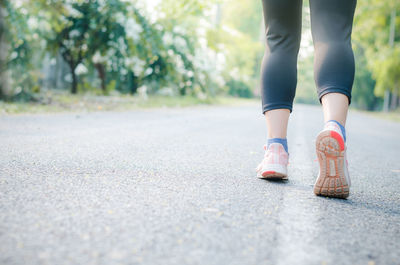 Low section of woman standing on road