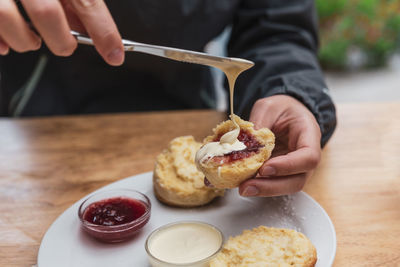 Cropped hands of person having breakfast on table