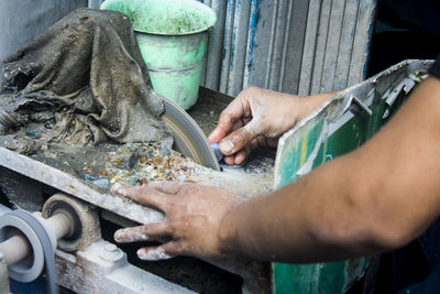 Cropped hands cutting tile at workshop