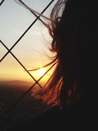 Close-up of silhouette woman against trees at sunset