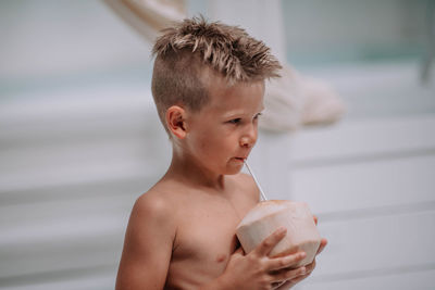 Portrait of shirtless boy drinking glass