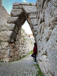 Rear view of man standing on rock formations