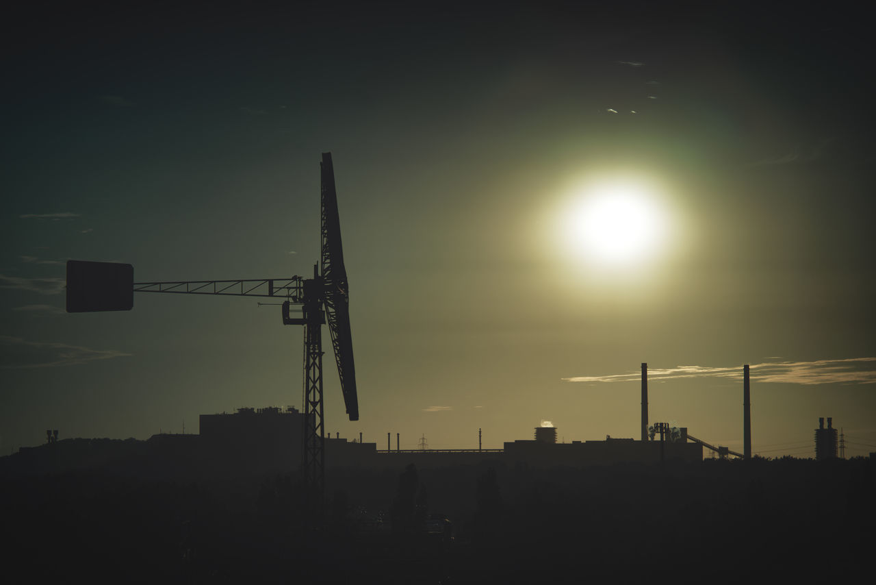 SILHOUETTE CRANES AGAINST SKY AT SUNSET