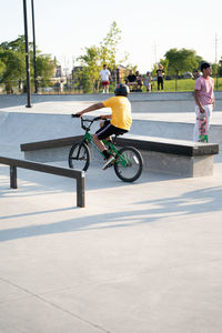 Rear view of man riding bicycle on street