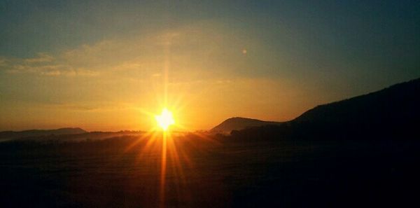 Scenic view of sunset over mountains