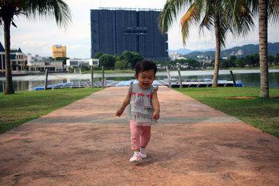 Full length of a girl standing on footpath