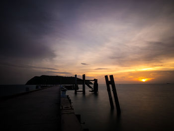 Pier over sea at sunset