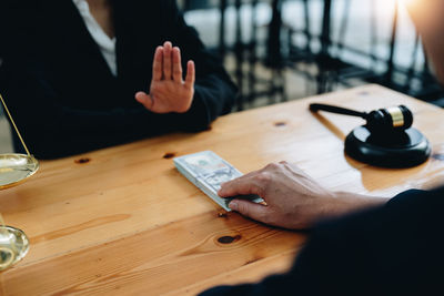 Midsection of lawyer using mobile phone