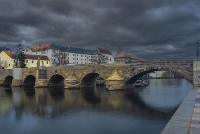 Bridge over river against cloudy sky