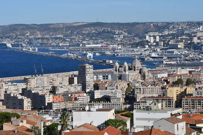 High angle view of townscape by sea against sky