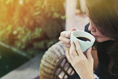 Close-up of woman having coffee while sitting at outdoor cafe