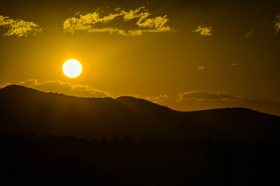 Scenic view of silhouette mountains against sky during sunset