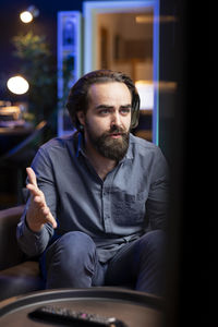 Portrait of man sitting on sofa at home