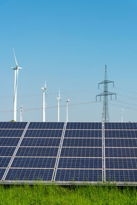 Low angle view of wind turbine against blue sky