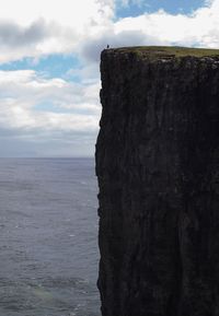 Rock formation by sea against sky