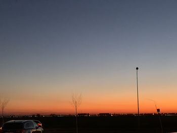 Silhouette street against clear sky during sunset