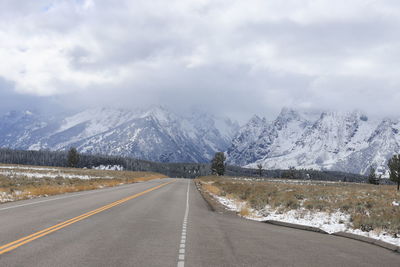 Road by mountains against sky