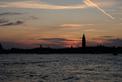 Silhouette of building against cloudy sky during sunset