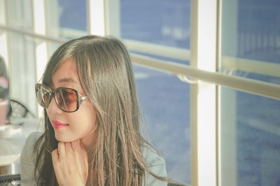 Close-up of young woman looking through window