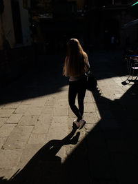 Rear view of woman walking on street