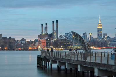 Light up empire state building is seen from east river park, brooklyn.