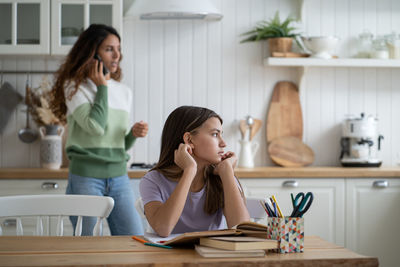 Young woman using mobile phone at home