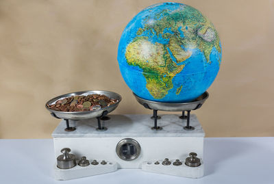 Close-up of clock and coins on weight scale