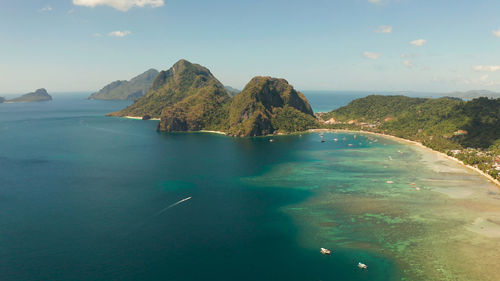 Bay with lagoon and turquoise water on a tropical island against the backdrop of the mountains. 