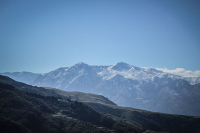 Scenic view of snowcapped mountains against clear blue sky