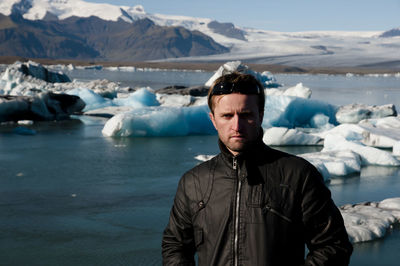 Portrait of man standing against frozen lagoon