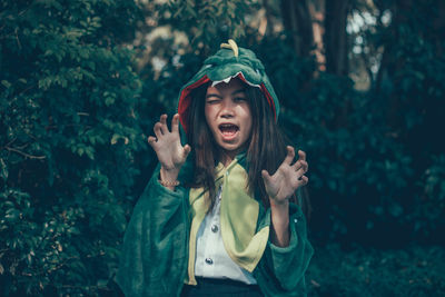 Full length of young woman standing against trees