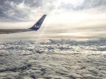 Airplane flying over cloudscape against sky