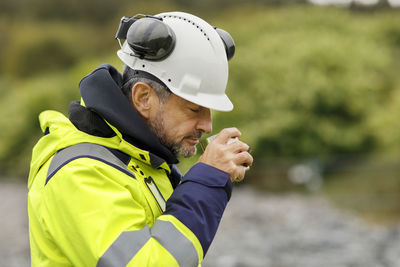 Male engineer in hard hat having drink