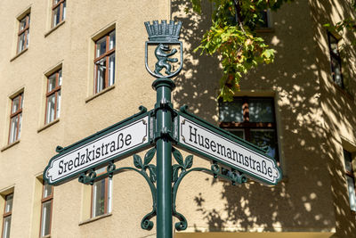 Low angle view of road sign against building