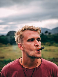 Portrait of young man smoking outdoors