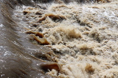 High angle view of waves splashing on beach