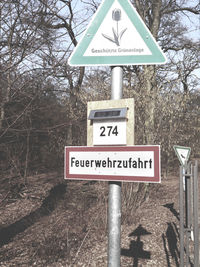 Close-up of road sign against sky