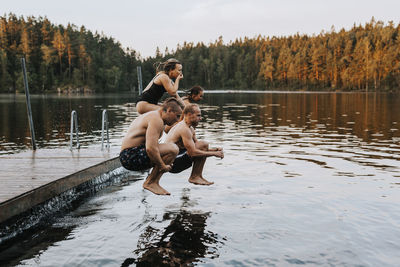 Friends jumping into lake