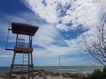 Lifeguard hut on beach against sky