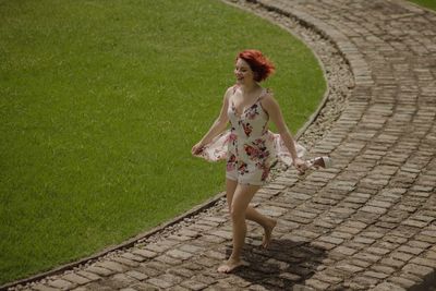 Full length of woman running on footpath