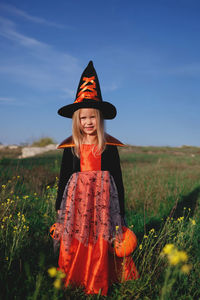 Full length of a smiling girl standing on field