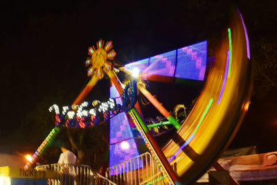 Low angle view of illuminated ferris wheel at night